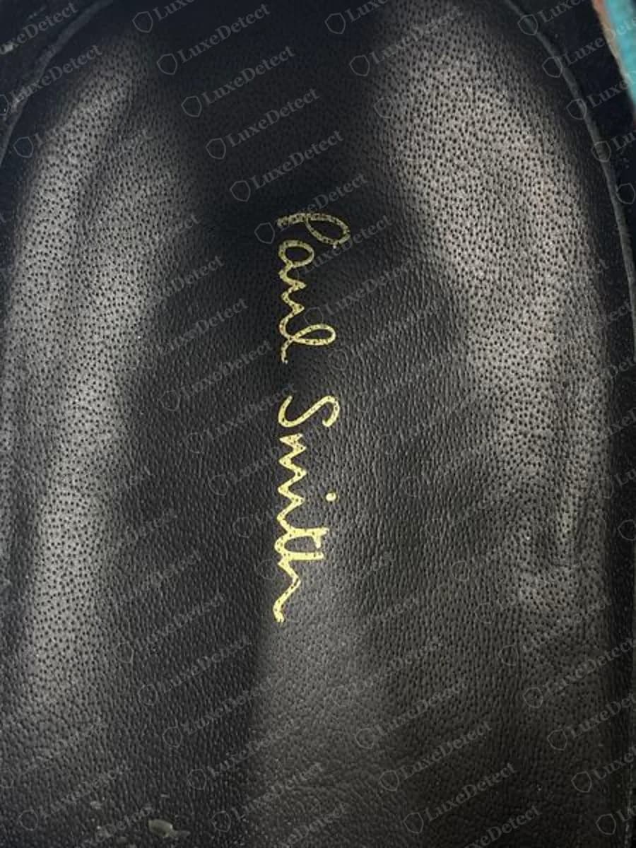 Genuine Paul Smith black leather insole with the script name Paul Smith stamped in gold foil running lengthwise, on the inside of a dress shoe
