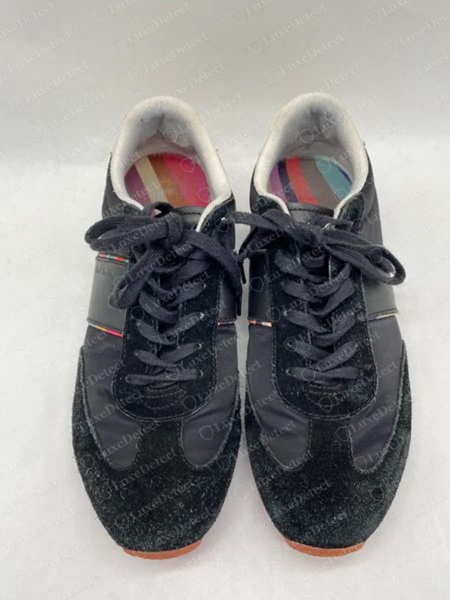 Genuine Paul Smith black sneakers seen from above, a multi-coloured striped lining inside each collar and a thin coloured stripe along the side panel
