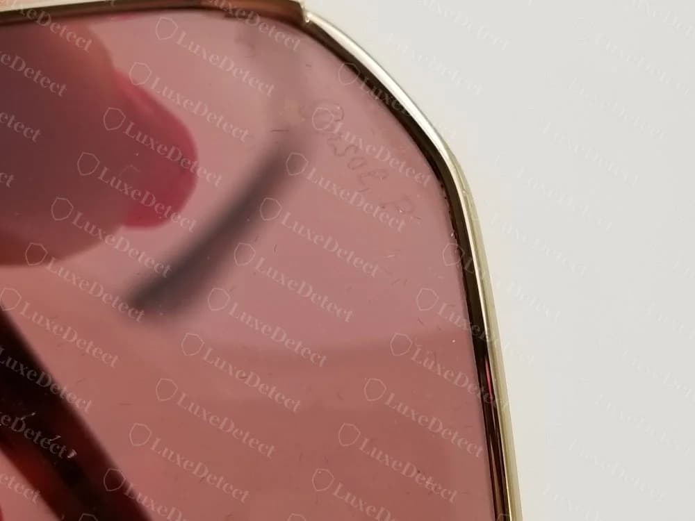 Lente de armação metálica Persol original com o logotipo Persol em letra cursiva e a letra P levemente gravados no canto superior de uma lente com tom rosado