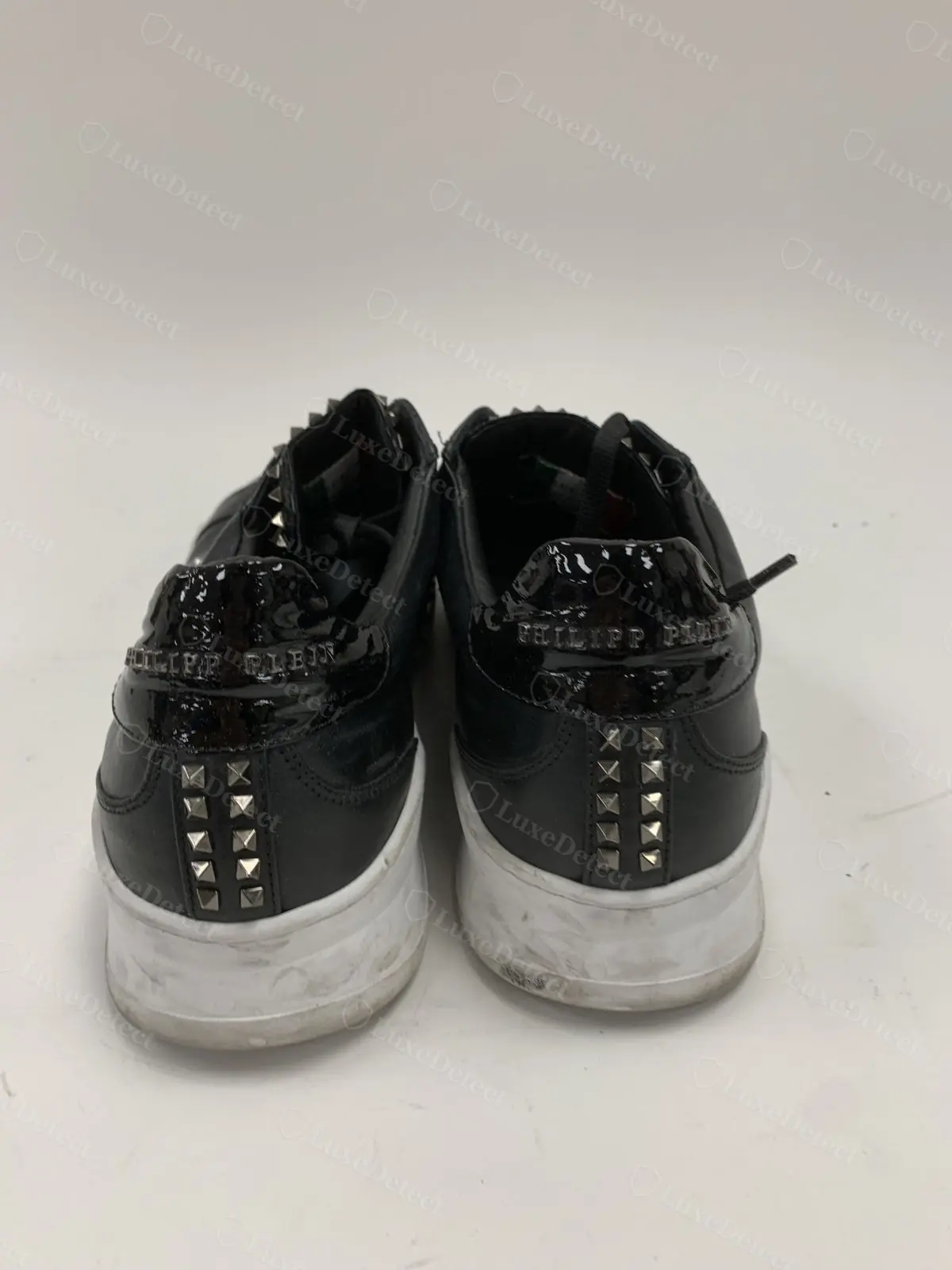 Counterfeit Philipp Plein heel, "Philipp Plein" text embossed into a patent-leather panel, less crisp than the genuine heel lettering
