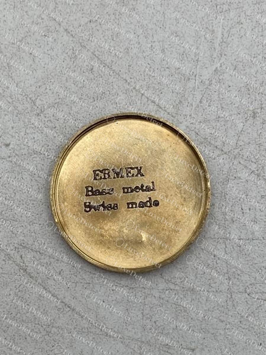 The same fake's caseback: stamped "ERMEX, Base metal, Swiss made," a different brand name entirely, on base metal rather than gold.