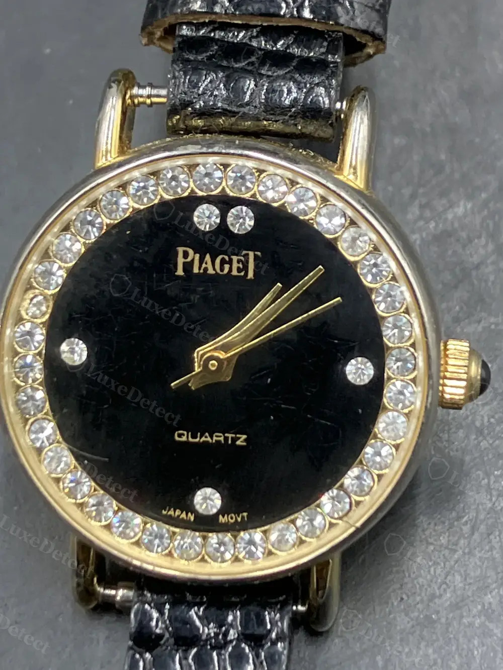 A fake diamond-bezel dress watch with "JAPAN MOVT" printed directly on the dial, under the diamond bezel.