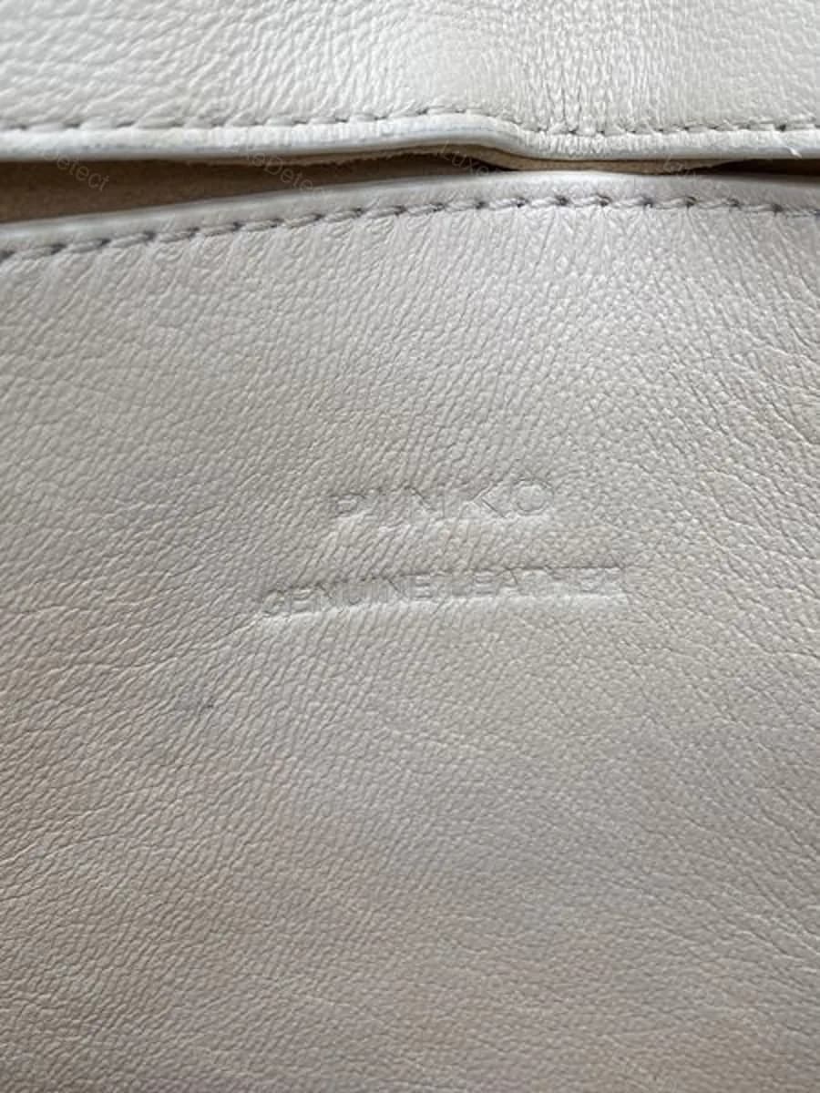 Authentic Pinko Love Bag interior, tonally embossed "PINKO GENUINE LEATHER" pressed into the lining leather itself