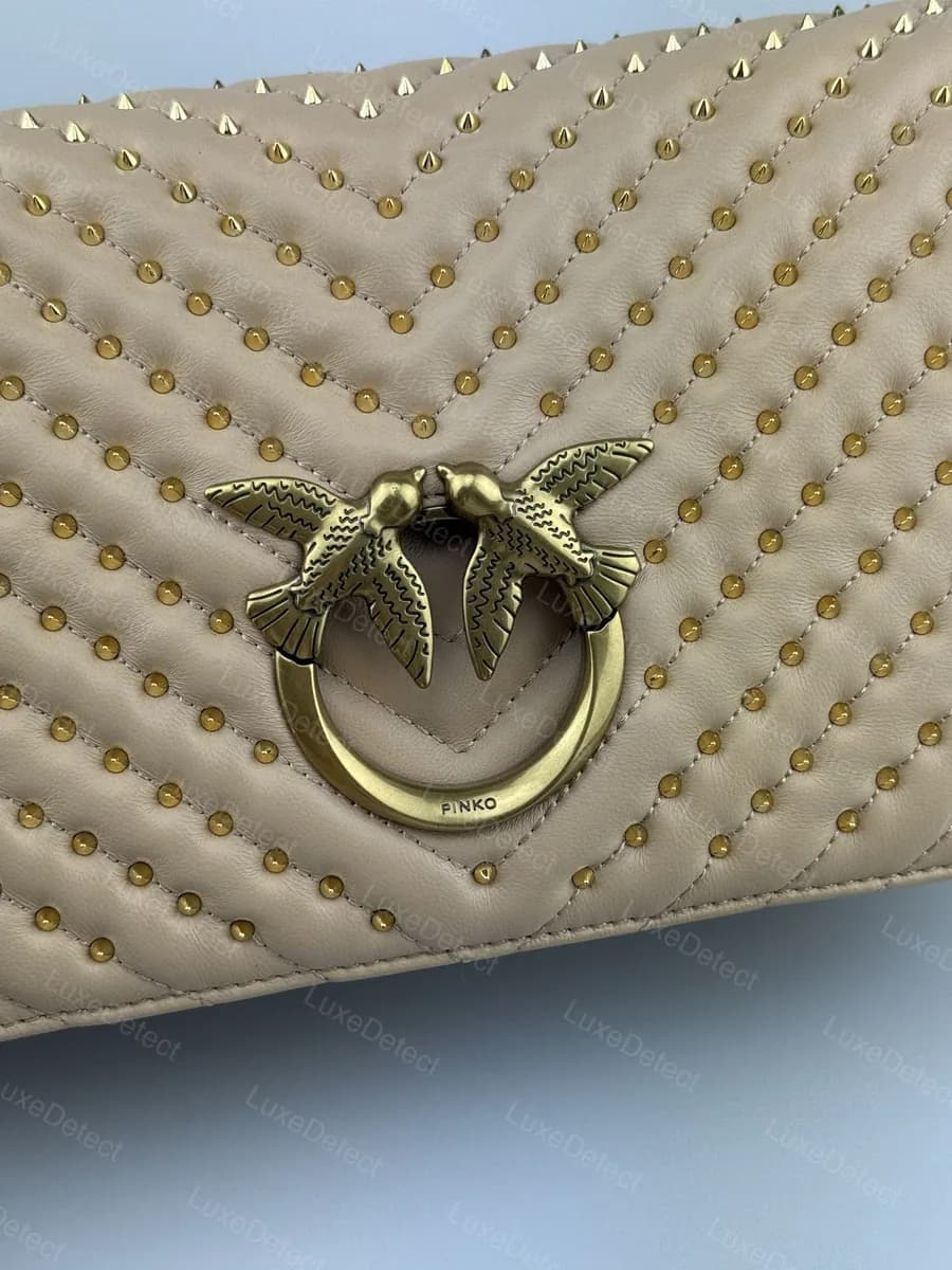 Authentic Pinko Love Bag clasp (studded variant), fine wing feather line-work and a clean "PINKO" ring stamp