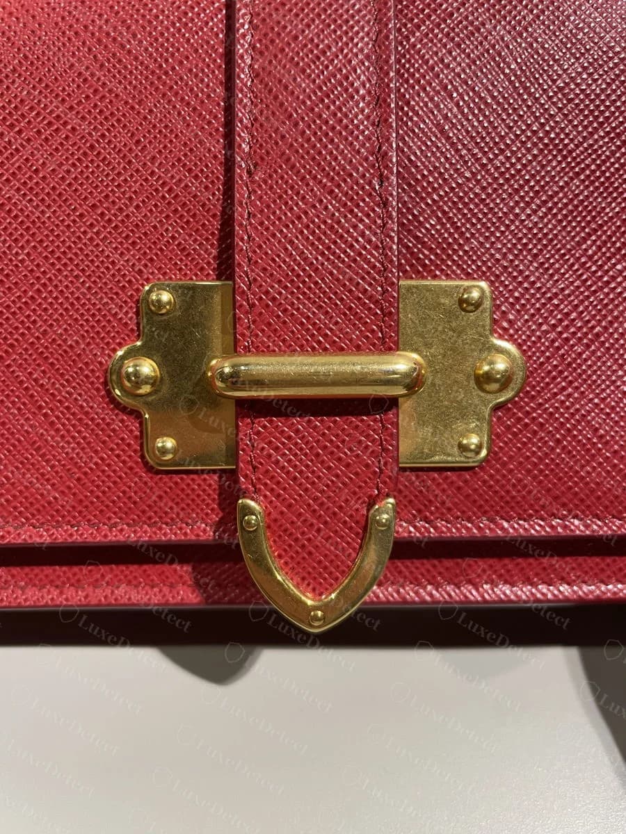 Genuine Cahier buckle plate: brushed brass finish, cross-shaped mounting plates, even rivet spacing