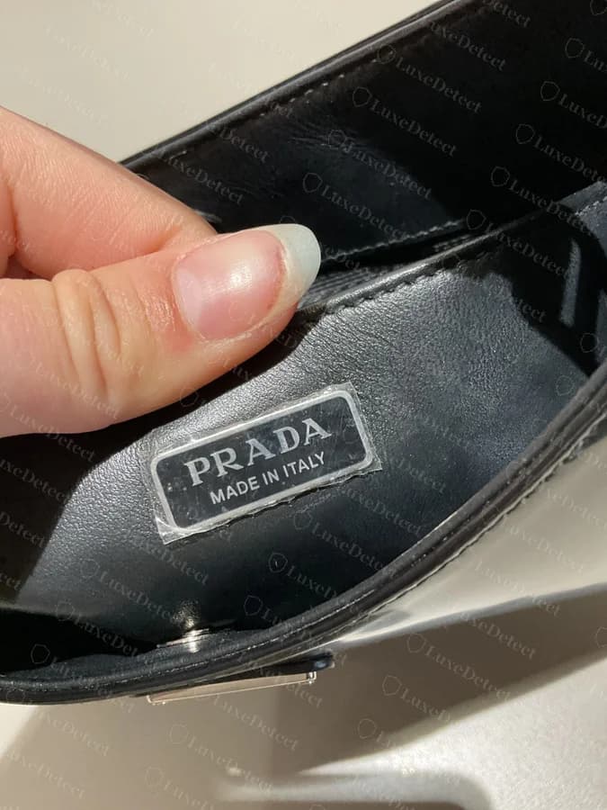 Counterfeit interior tag still carrying a visible protective film with a peel tab