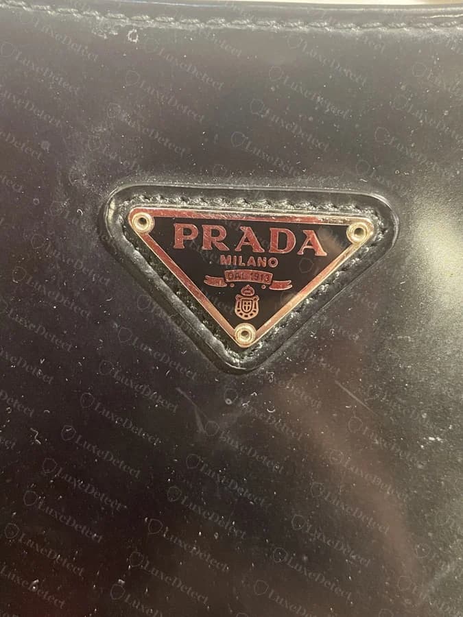 A second counterfeit example showing the same red-tinted plaque on a different bag
