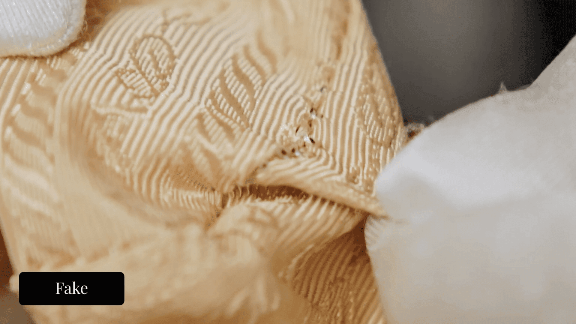 Prada Galleria interior lining — fake example showing fabric fraying and loose threads at a seam edge, a durability tell consistent with lower-grade replica material