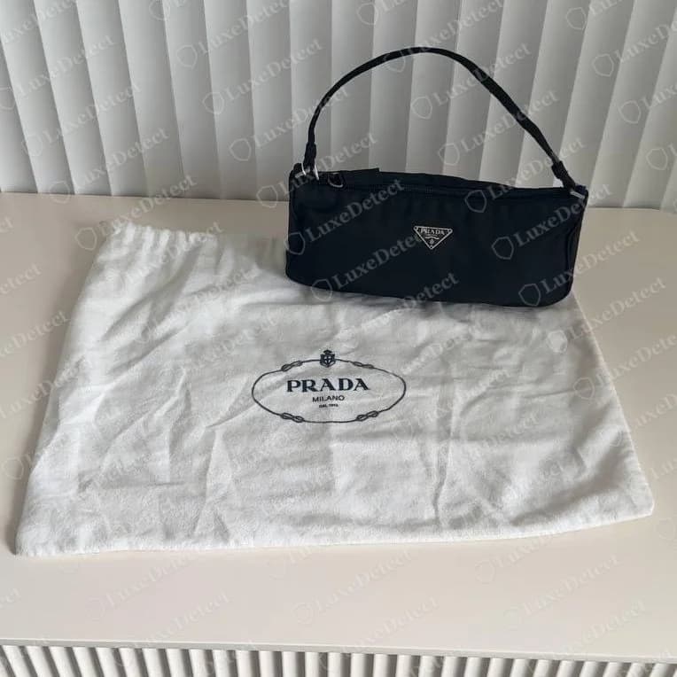 Echte Prada-Nylon-Pochette mit ihrem weißen Kordelzug-Staubbeutel aus Baumwolle, bedruckt mit dem schwarzen ovalen Logo "PRADA MILANO"