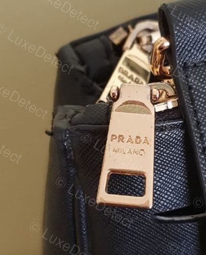 A fake Prada zipper pull for comparison — engraving quality alone won't always separate real from fake at this level; treat it as one signal, not a standalone verdict
