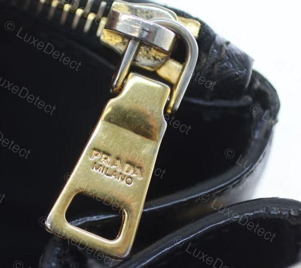 Genuine Prada zipper pull — "PRADA MILANO" engraved centered and even on the tab