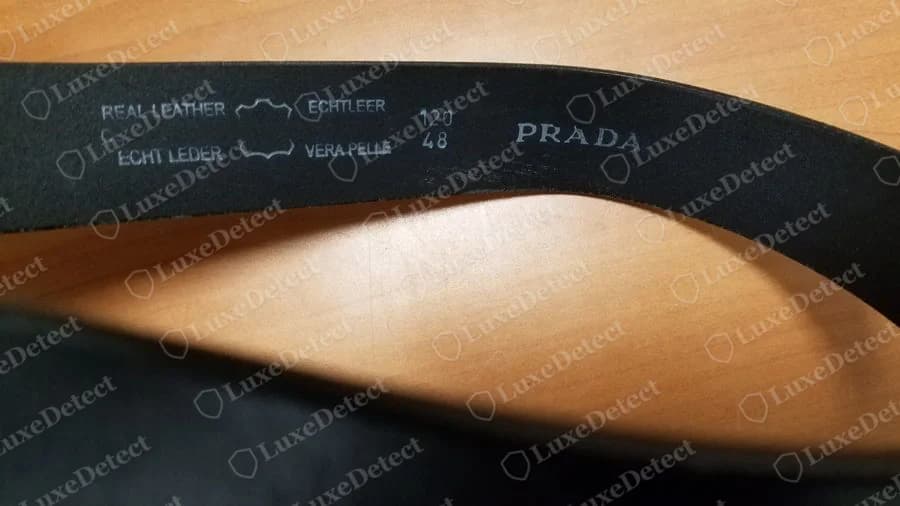 Cinturón Prada falso: bloque impreso REAL LEATHER y VERA PELLE con pictogramas de piel junto a una impresión PRADA