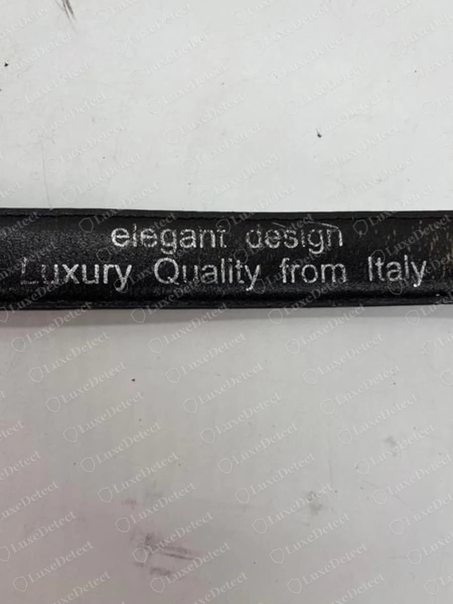 Cinturón Prada falso: eslogan impreso en plateado "elegant design, Luxury Quality from Italy" en la parte de abajo de la correa