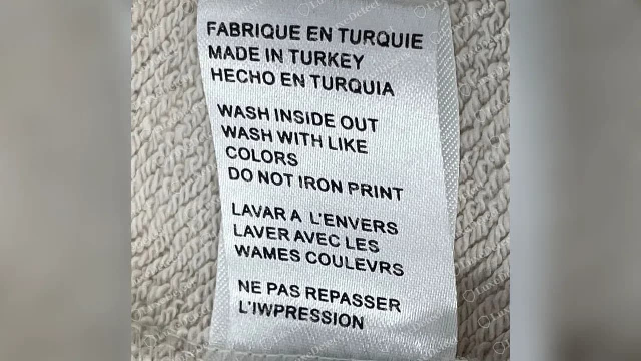 Counterfeit Prada sweatshirt care label: "MADE IN TURKEY", generic washing text with "WAMES COULEVRS" and "L'IWPRESSION", and no code line, RN number or Prada importer.