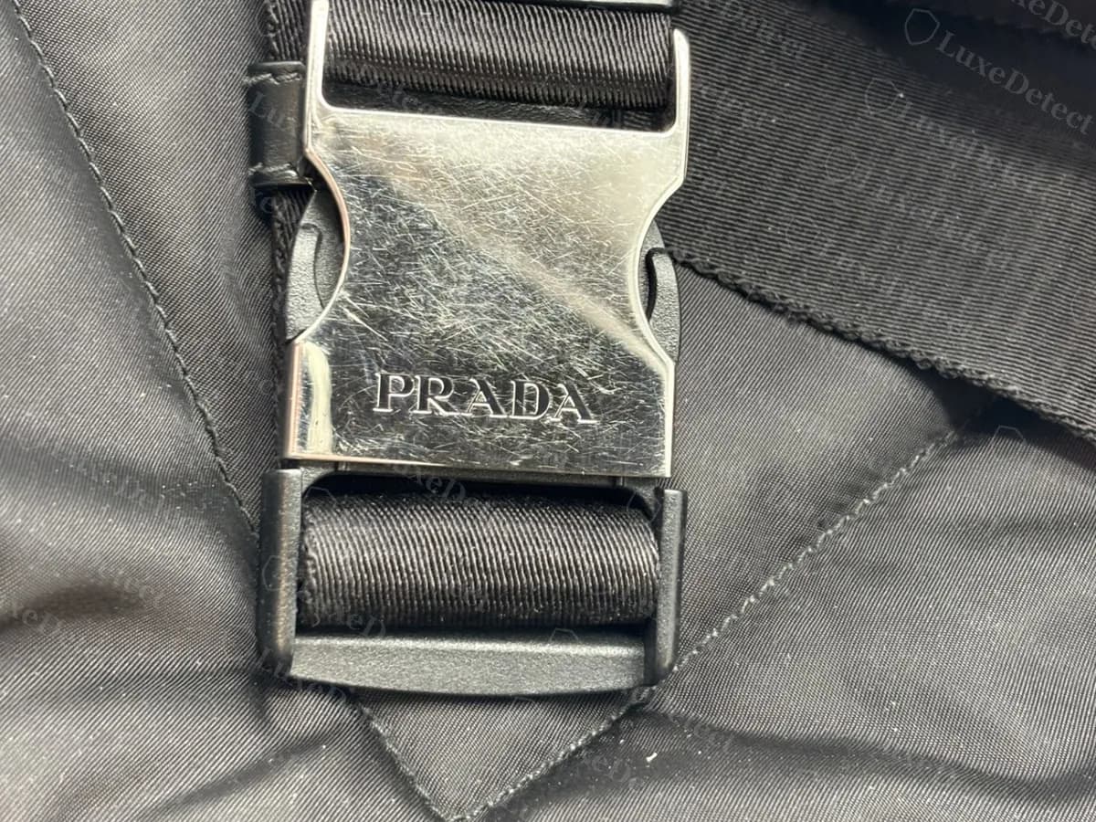 Genuine Prada backpack side-release buckle in silver-tone metal, engraved PRADA, on a black webbing strap