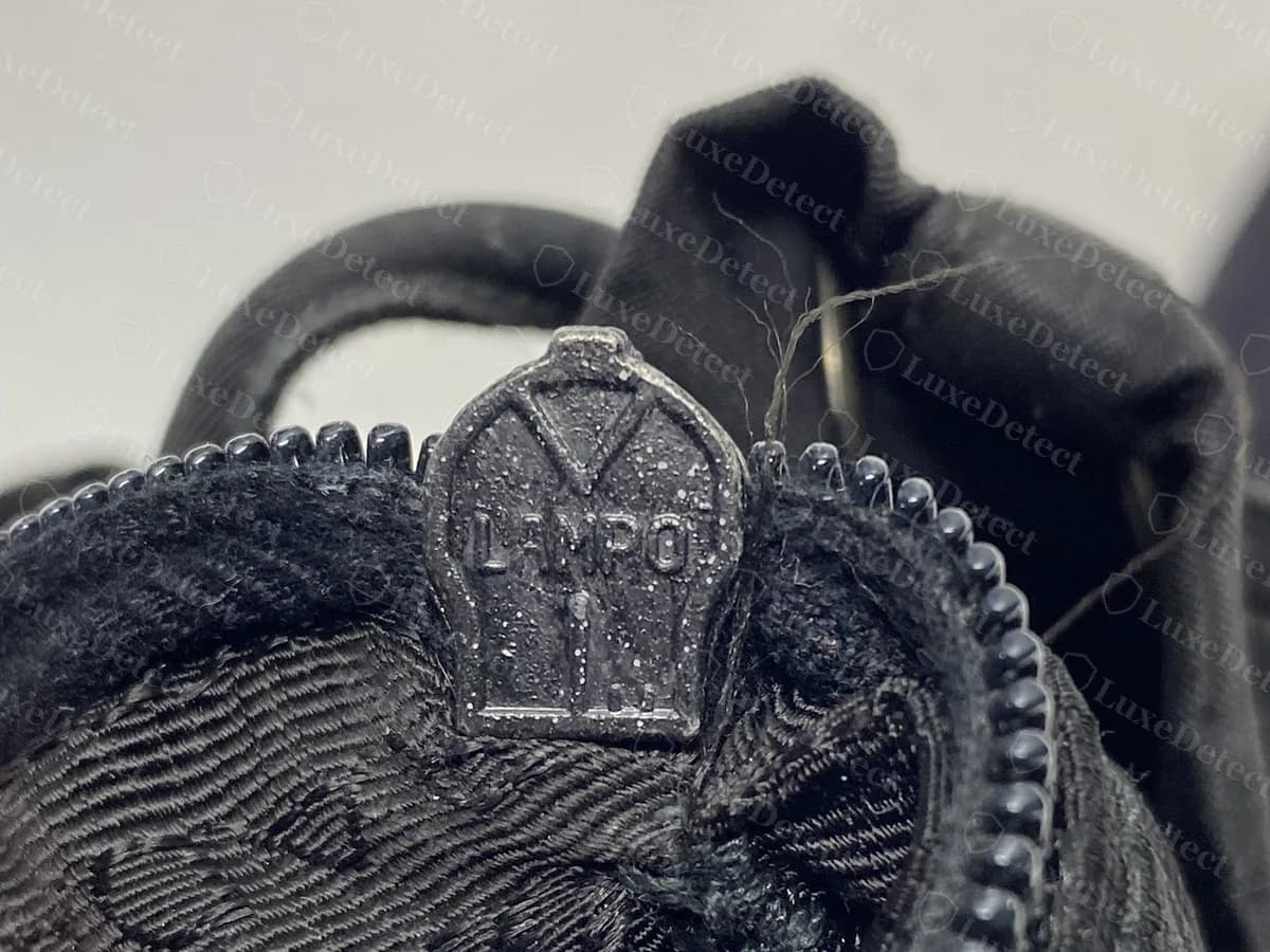 Genuine Prada backpack zip pull marked LAMPO, a zip maker's name, at the top of the interior zip