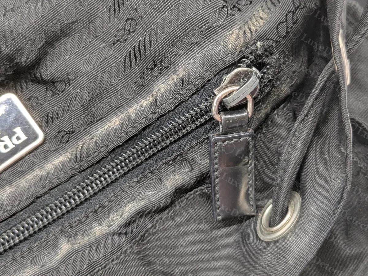 Genuine Prada backpack inner zip with a black leather-tipped pull and a drawstring eyelet
