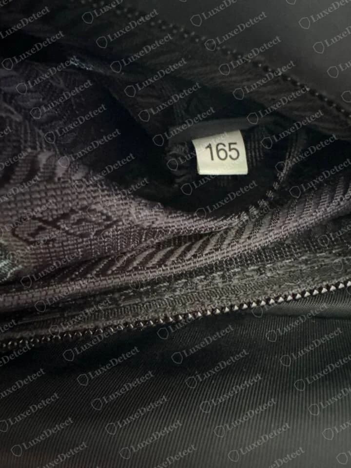 Eine gefälschte Prada Nylontasche mit weißem Etikett mit der Nummer 165 im Futter, dieselbe Nummer wie in echten Taschen