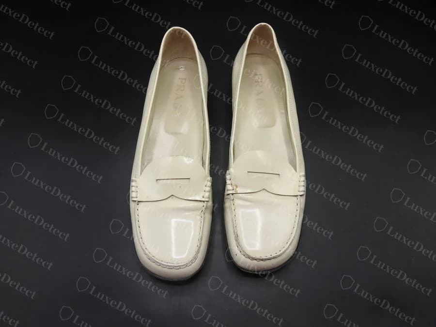 Counterfeit loafer insole, embossed gold "PRADA" stamp, comparably clean and legible to the genuine example above