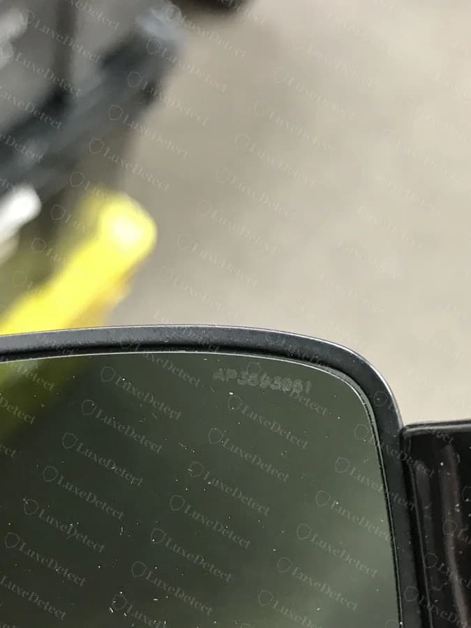 An authentic lens showing a faint laser-etched alphanumeric code near the upper corner.