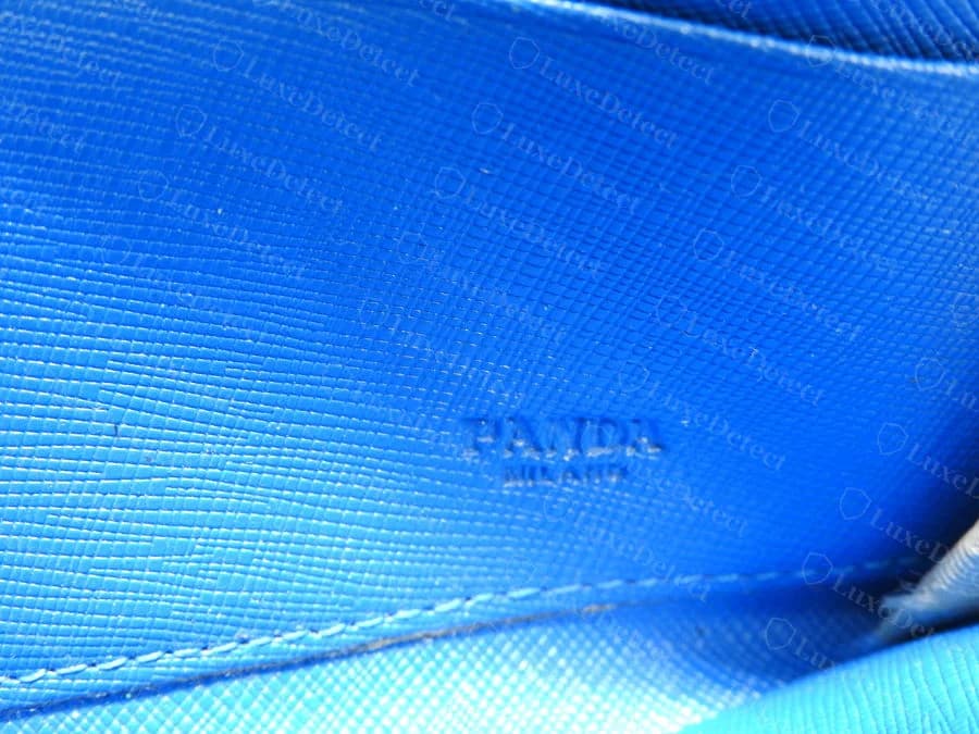 Prada wallet interior hot-stamp, counterfeit — reads "PANDA MILANO" instead of "PRADA MILANO," an outright misspelling rather than a quality difference