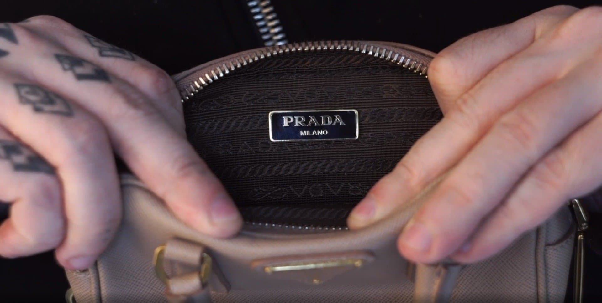 Authentic Prada interior — metal enamel plaque reading "PRADA MILANO" on saffiano fabric lining