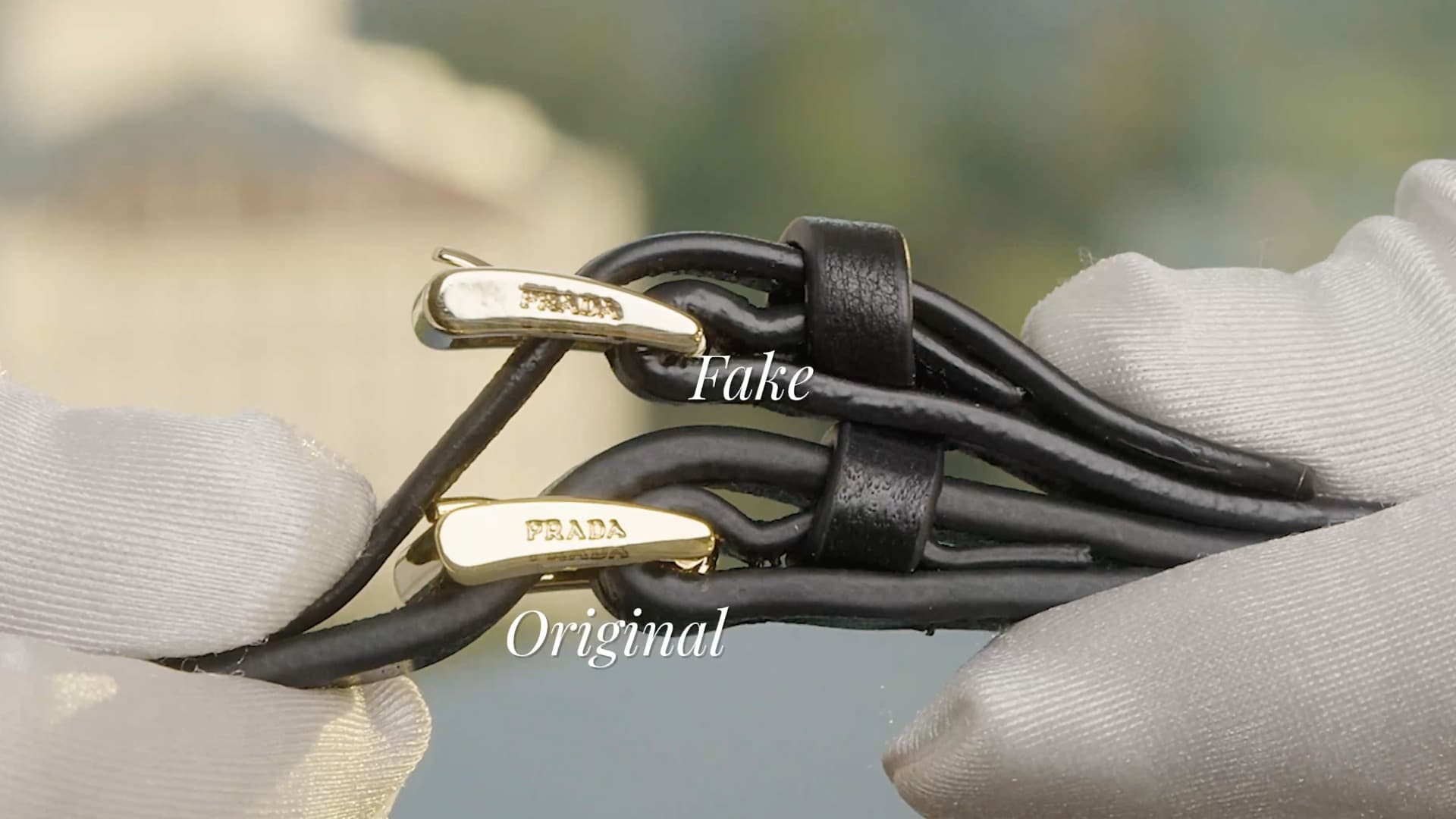 Zipper pull comparison — authentic Prada engraving (bottom) vs fake (top). Note engraving depth and metal finish