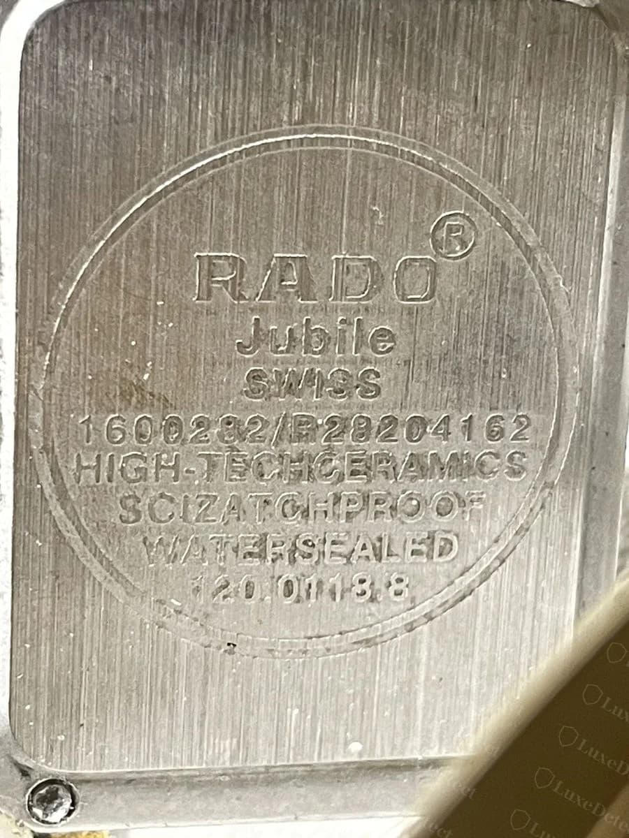 Counterfeit Rado Jubilé caseback: "HIGH-TECHCERAMICS" engraved as one run-together word with no space, and "SCIZATCHPROOF" directly below it, a garbled misspelling of SCRATCHPROOF, while WATERSEALED on the next line is spelled correctly