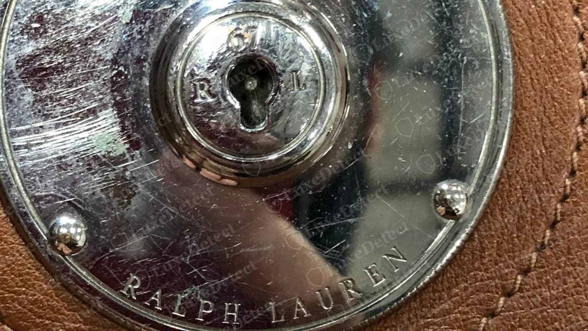 Cierre Ricky falso de un bolso que encontramos falso: también tiene tornillos en el borde, un cilindro 67 / R / L y RALPH LAUREN grabado alrededor del borde inferior