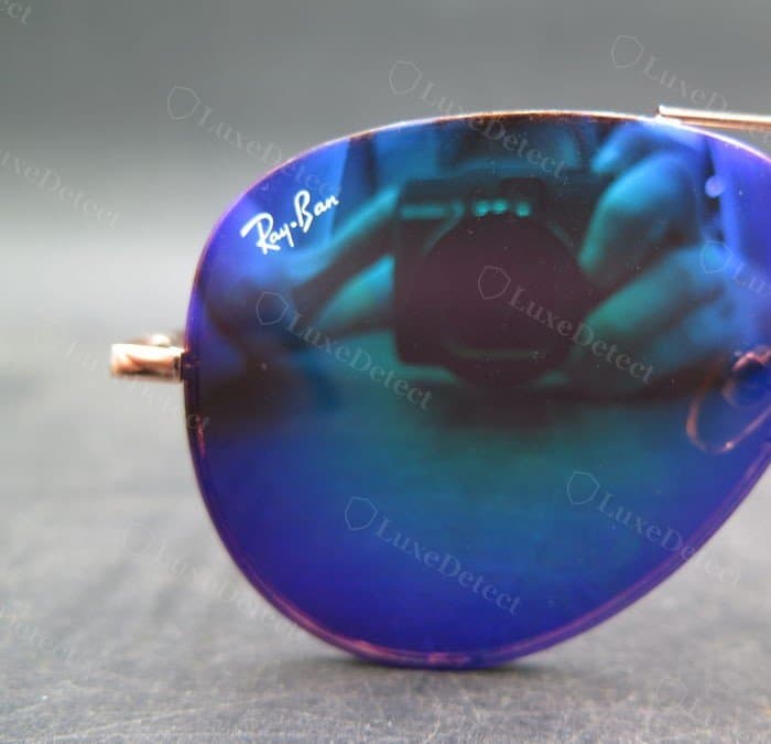 Counterfeit lens on a mirrored Aviator: the Ray-Ban script is present and reasonably clean — this etching alone would not catch this pair