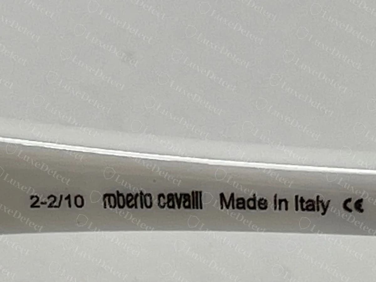 Interior de la varilla de unas gafas de sol Roberto Cavalli originales, impreso con una marca de fecha, roberto cavalli, Made in Italy y una marca CE sobre acetato blanco