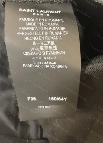 Genuine 2021 care label from a pair of uniform trousers made in Romania, with the full extended language set and a Y at the start of the code group; the number after the year is blurred.