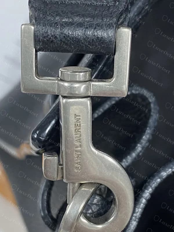 Genuine Sac de Jour strap clasp: a swivel snap hook in aged silver, engraved SAINT LAURENT along the body