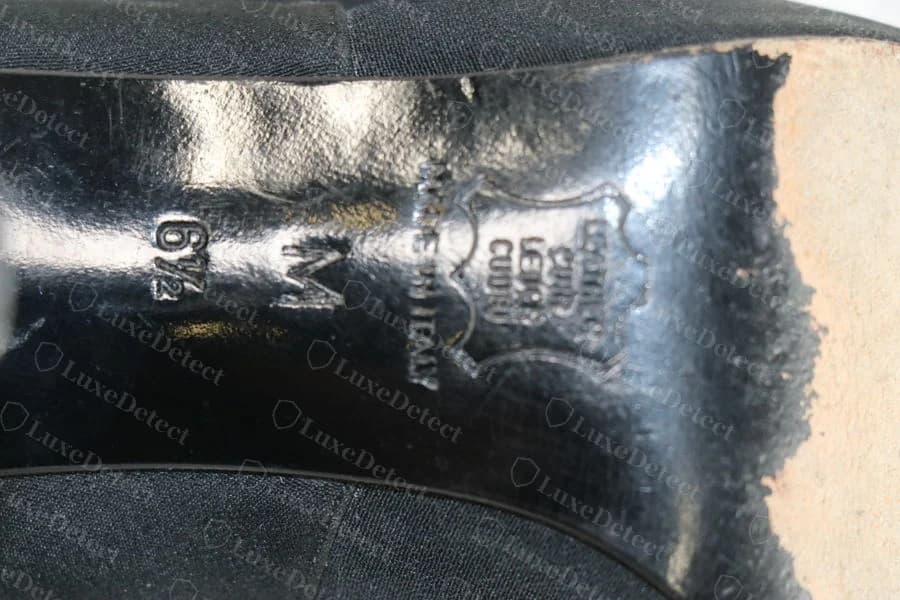 Genuine leather-crest oval stamp reading "GENUINE LEATHER MADE IN ITALY" in a heraldic-shield layout, a third distinct legitimate format, on a black patent slingback pump.