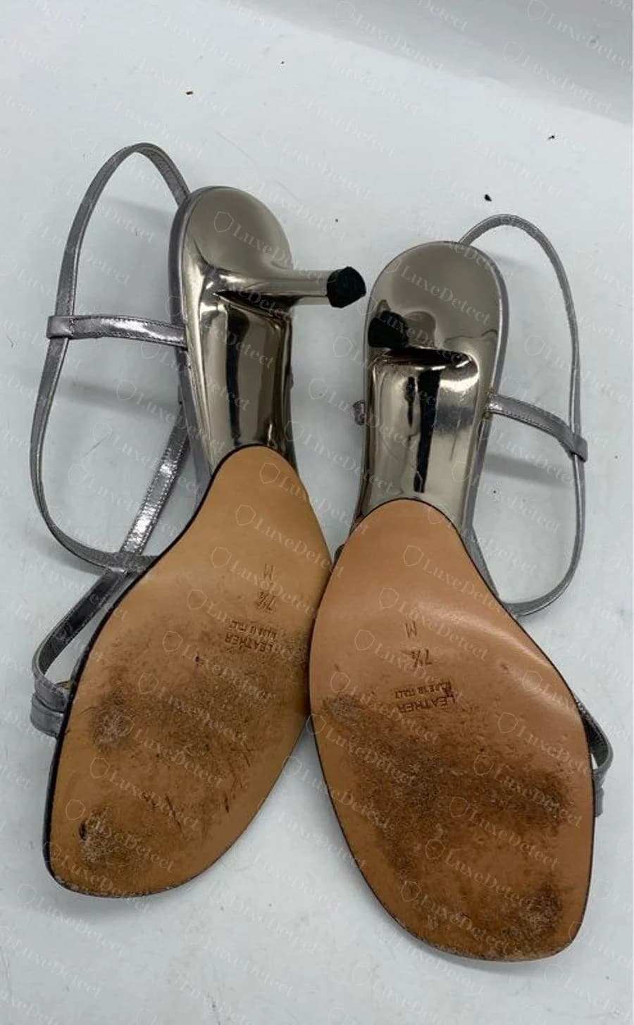 A second, separately confirmed genuine outsole reading "LEATHER / MADE IN ITALY / 7½ M," near-identical wording to the pump above but on an unrelated metallic sandal.