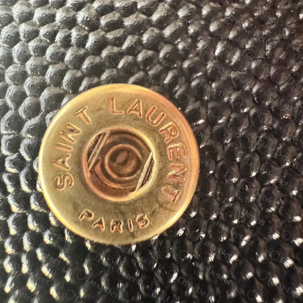 Genuine flap card holder: the snap stamped SAINT LAURENT around the rim and PARIS below, on caviar-grain leather
