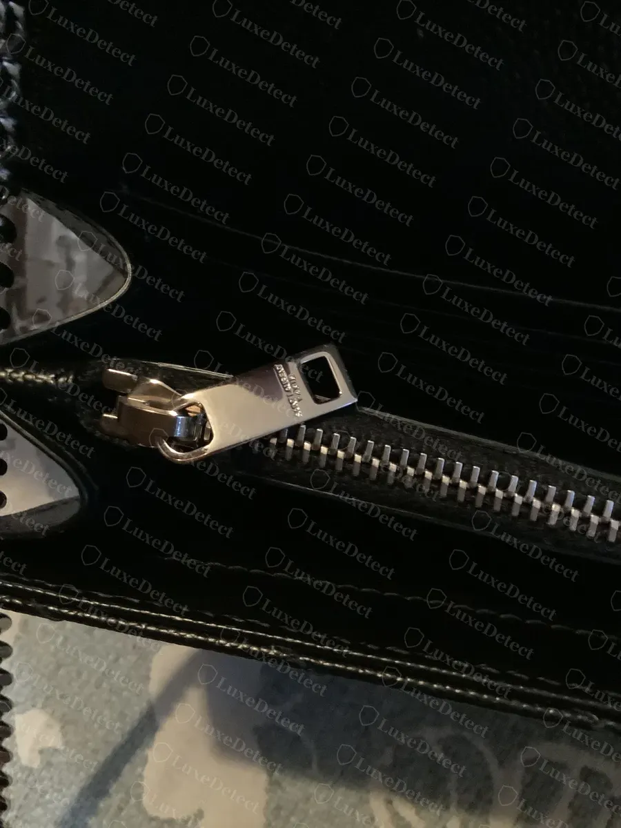 Genuine interior zip pull, engraved SAINT LAURENT PARIS in small text on the pull tab, evenly spaced zipper teeth