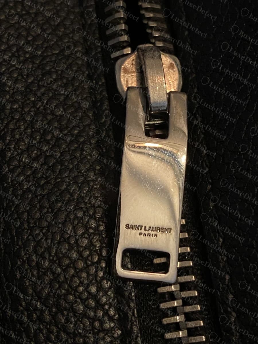 Genuine zipper pull stamped "SAINT LAURENT PARIS," lettering shallow but legible under normal light.