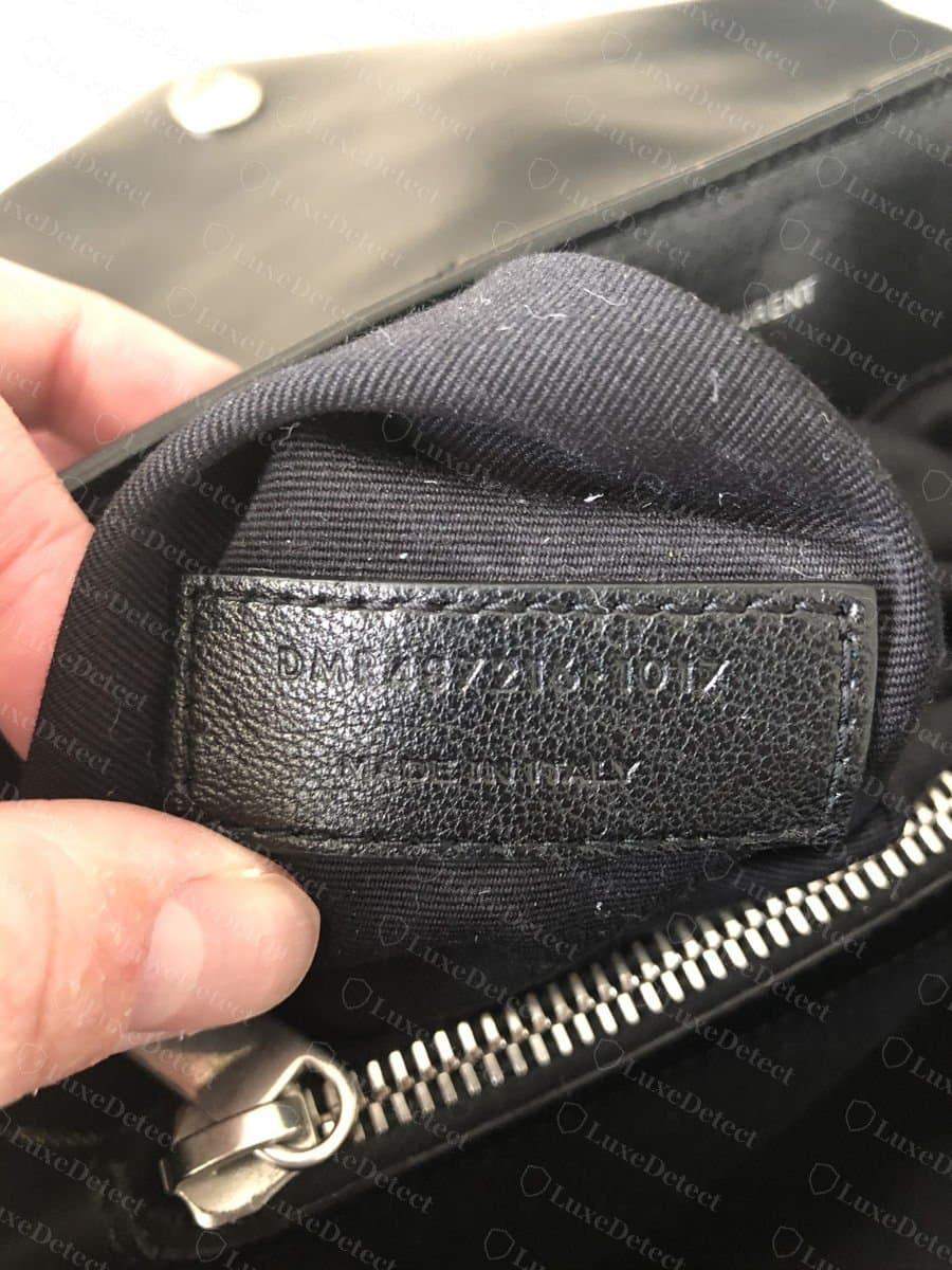 Languette de numéro de série Saint Laurent authentique en cuir, cousue sur tous les côtés à l'intérieur de la doublure près de la fermeture éclair, avec le numéro de série et MADE IN ITALY estampés dans la surface