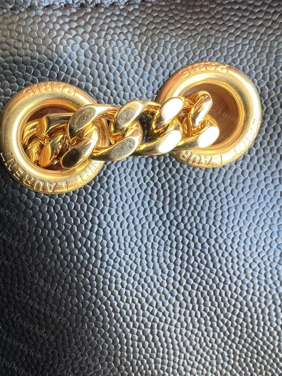 Counterfeit Saint Laurent Envelope strap rings, both cast with "PARIS" and "LAURENT" mirror-reversed