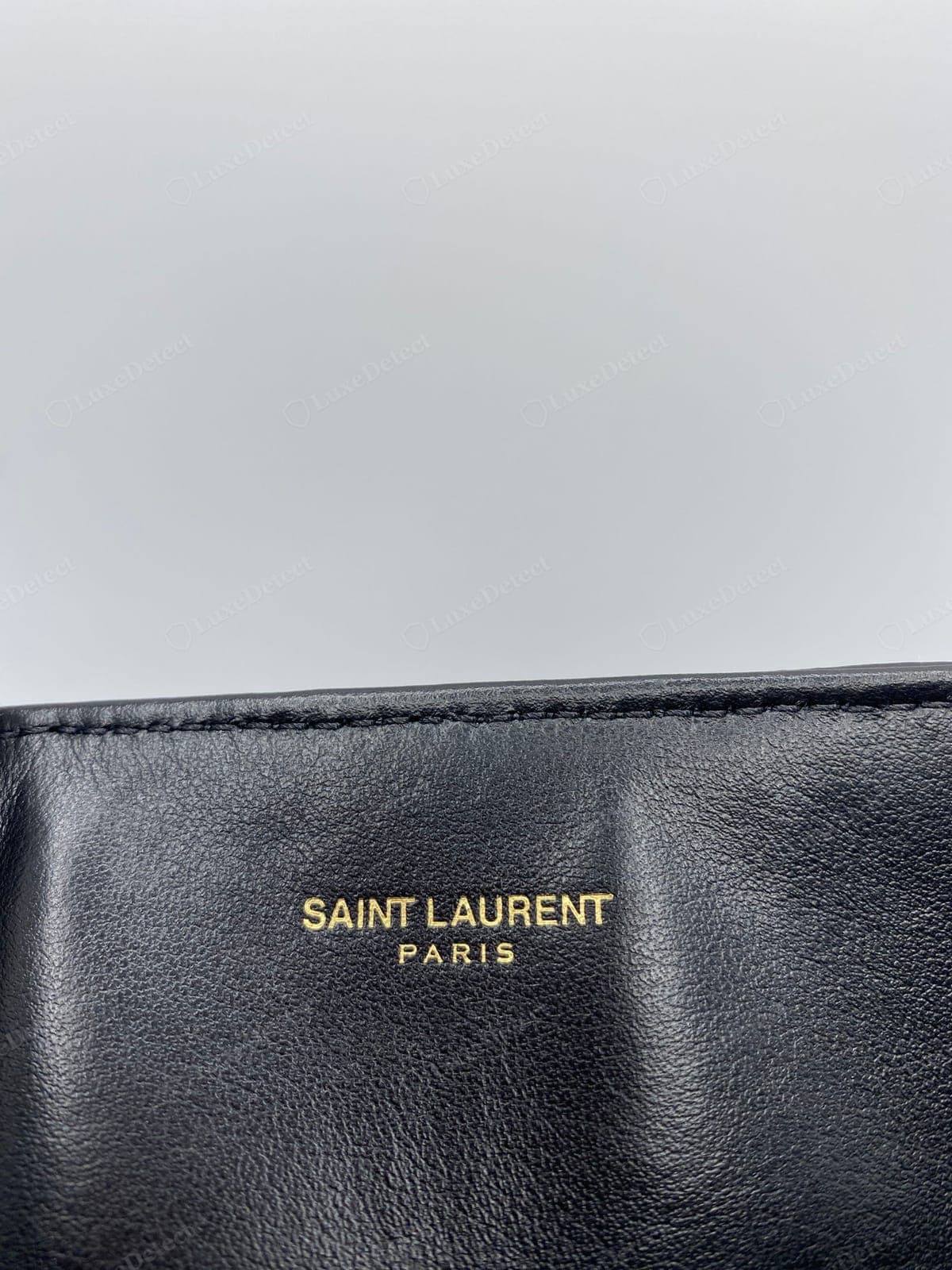 Gaufrage « SAINT LAURENT PARIS » d'un Saint Laurent Loulou authentique : pressé proprement dans le cuir, en capitales espacées correctement