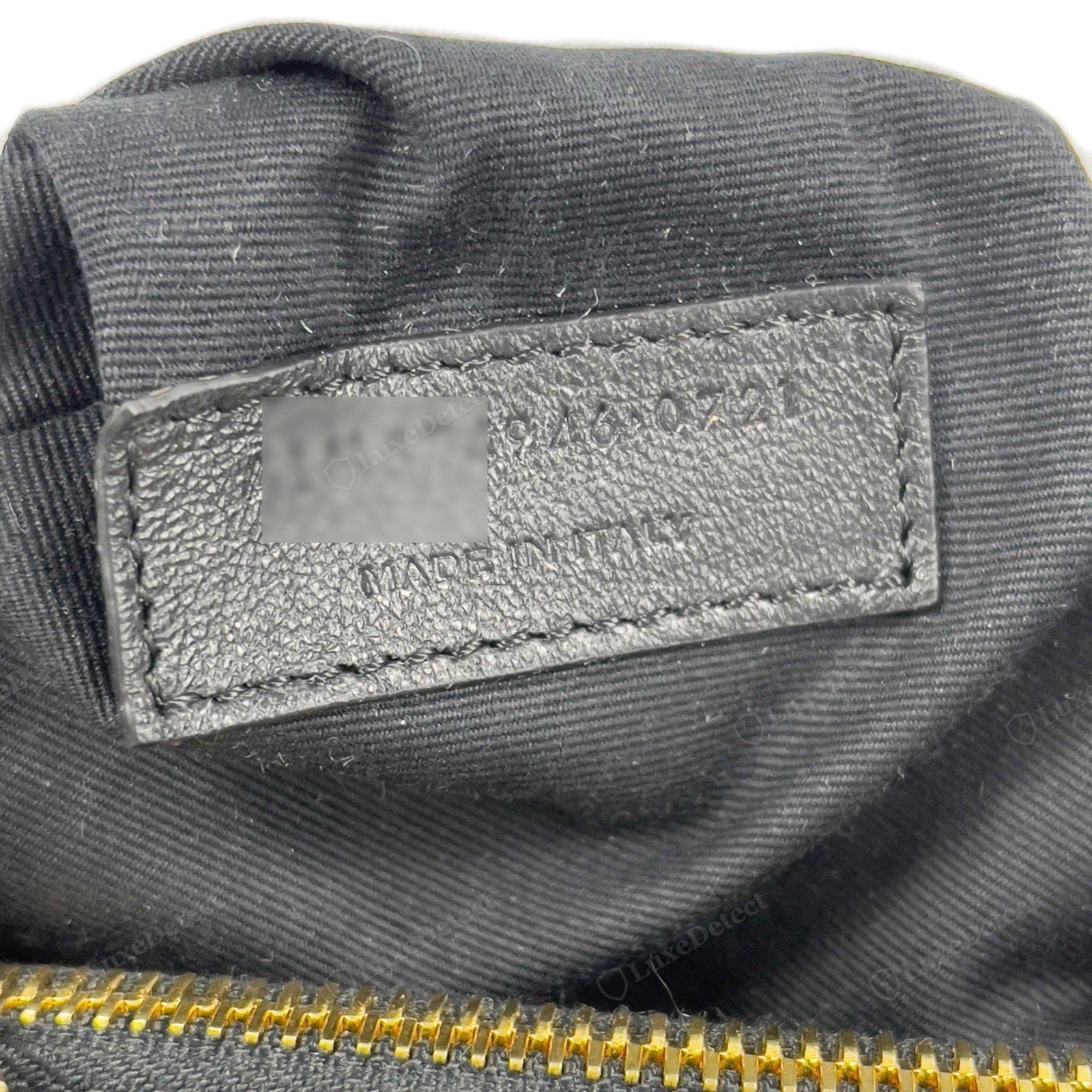 Número de serie de un Saint Laurent Loulou falso: un "número de serie" y "made in Italy" en una lengüeta con el formato equivocado o un estampado torpe