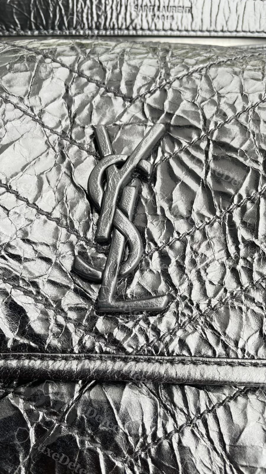 Counterfeit Saint Laurent Niki YSL logo on a black Niki, cleanly cast with sharp letterforms and comparably deep quilting