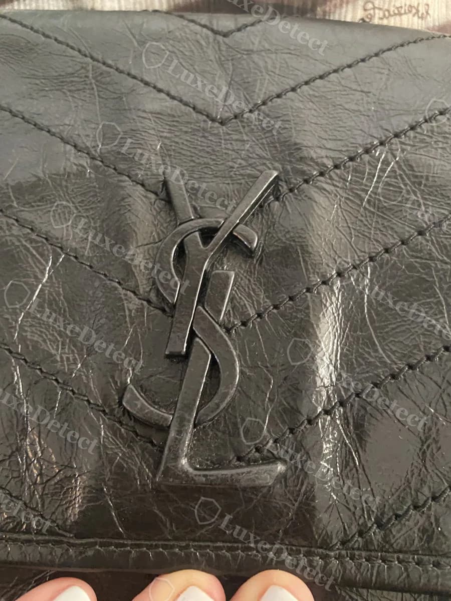 Authentic Saint Laurent Niki YSL logo hardware set into deep, well-defined chevron quilting on a medium Niki