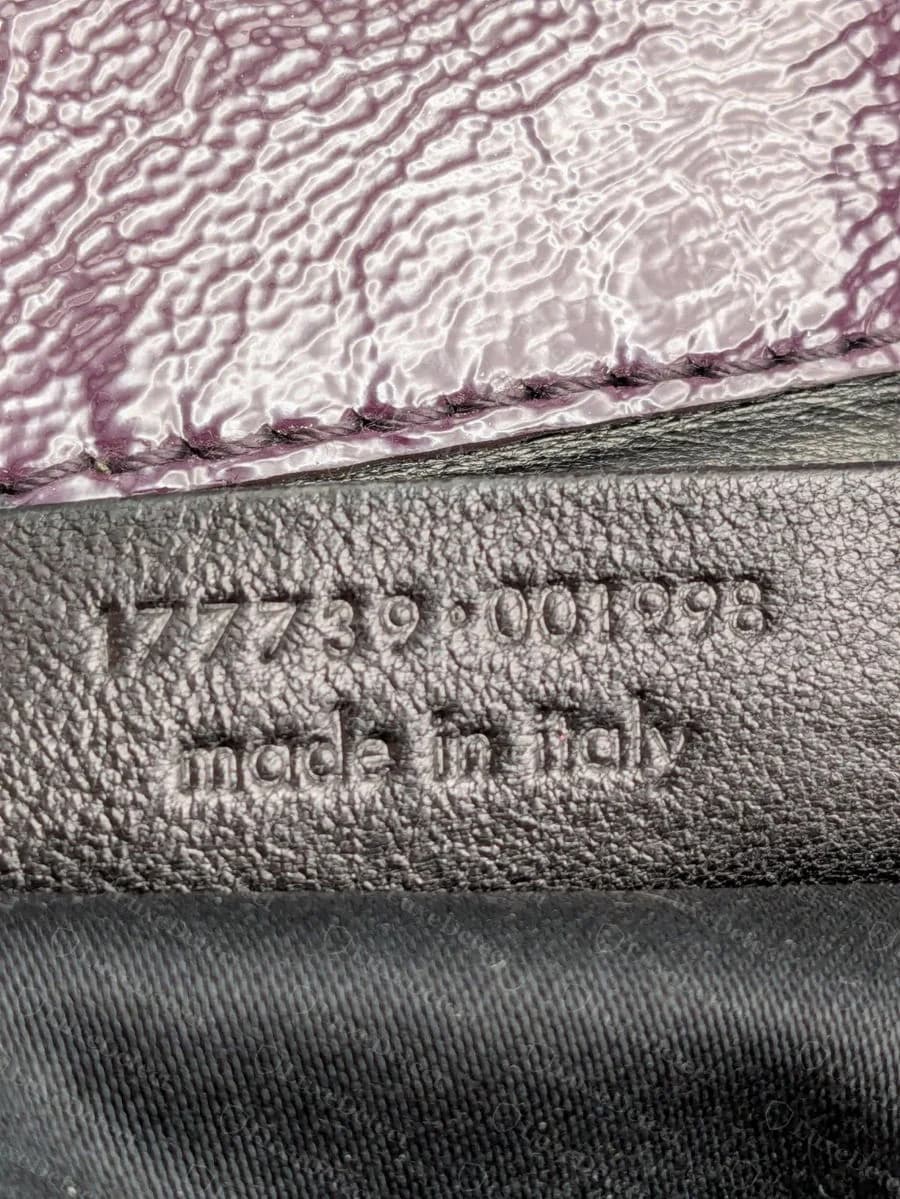 The serial number is embossed directly into a leather strip below the interior label, followed by "made in italy."