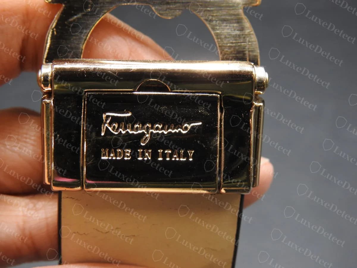 Genuine reversible belt clamp: "Ferragamo" script and "MADE IN ITALY" engraved on the polished gold-tone plate of the hinged clamp
