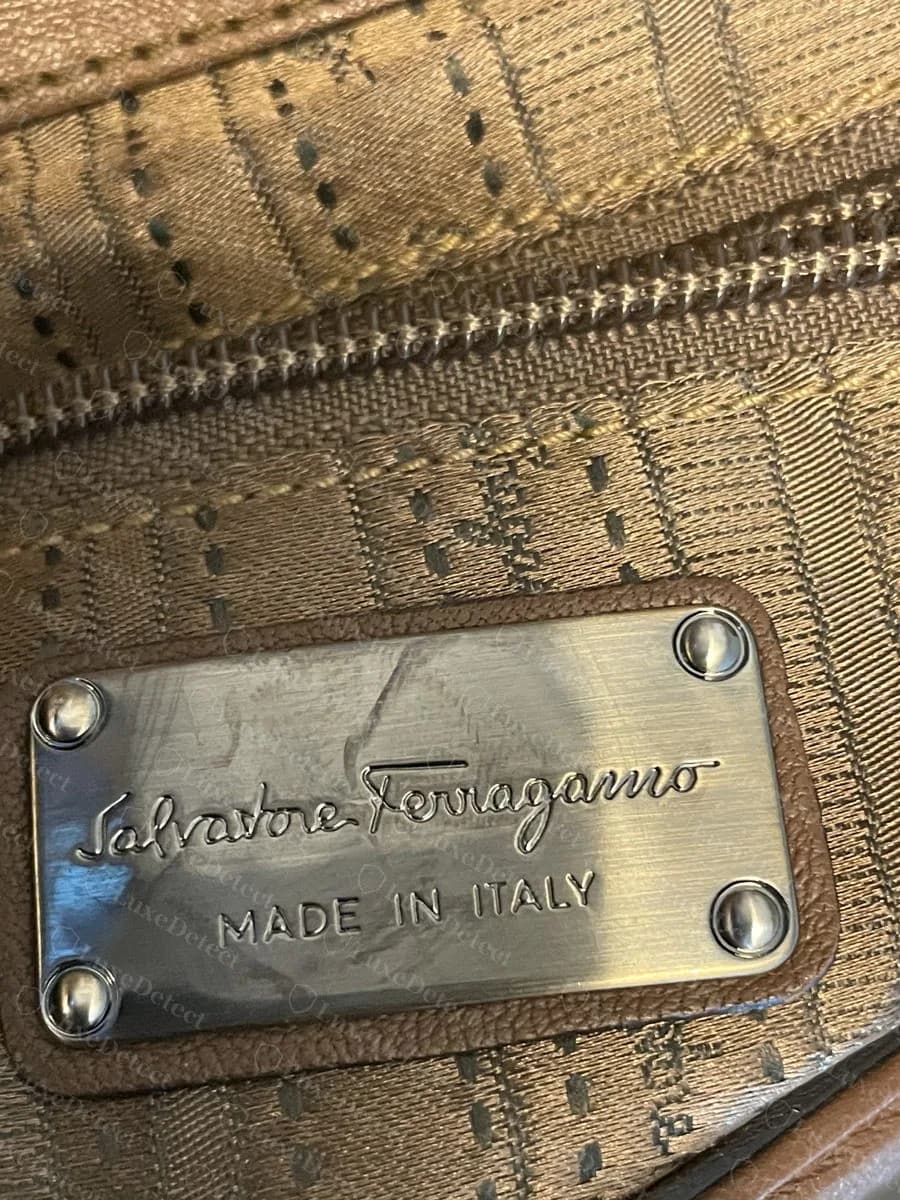 A riveted metal plate inside a genuine Ferragamo bag reading Salvatore Ferragamo and MADE IN ITALY with no code on it