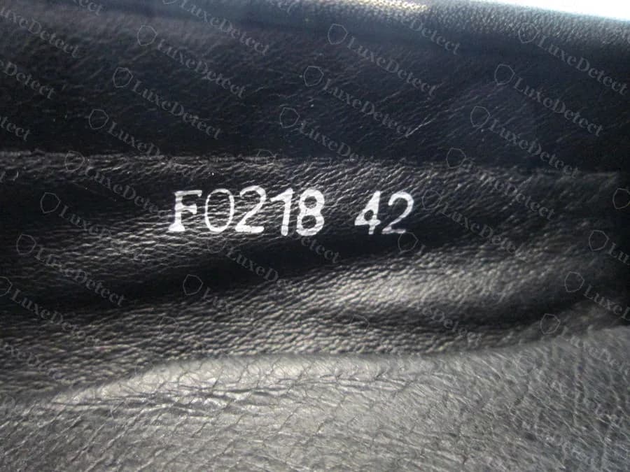 A counterfeit pair's lining print reading F0218 42: no US size, no width letter and an EU size 42 where a US size belongs