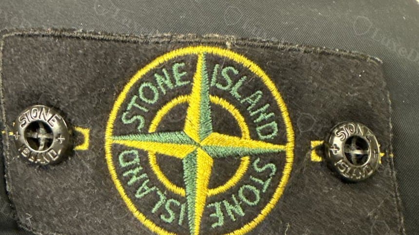 Authentic compass badge: the classic colourway is two-tone, a gold-yellow compass rose set inside a distinct mossy green ring and lettering.