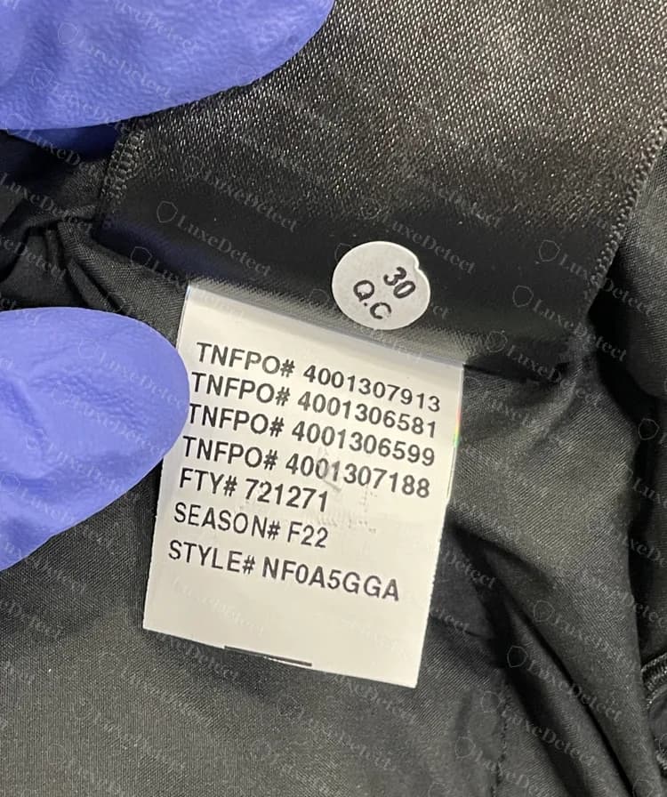 Etiqueta de fábrica genuina: números de pedido TNFPO, número de fábrica FTY, SEASON F22 y STYLE NF0A5GGA, con una pegatina redonda de control de calidad encima